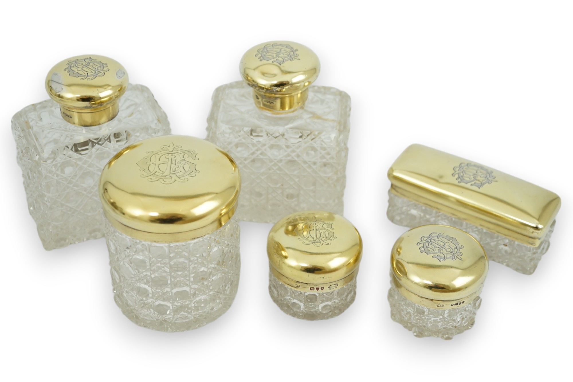 A matched suite of six late Victorian silver gilt mounted cut glass toilet jars two by Charles & George Asprey, London, 1893, tallest 12.2cm.